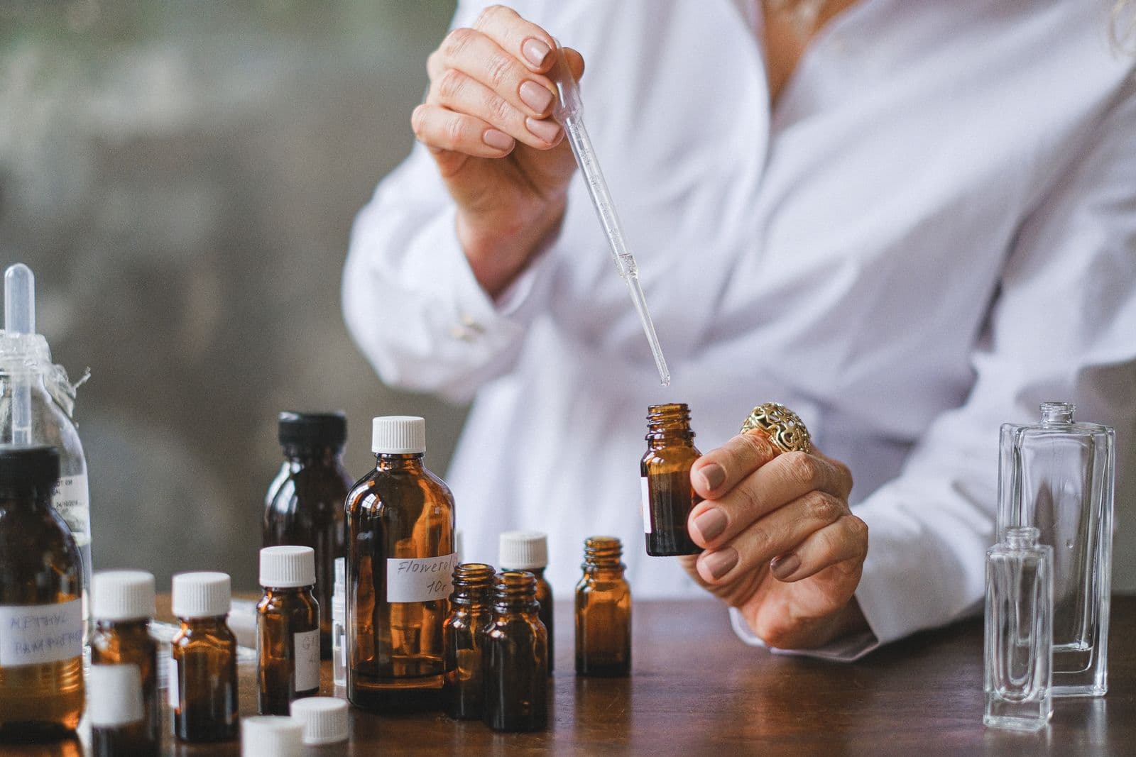 Small amber glass bottles and a glass dropper on a wooden table
