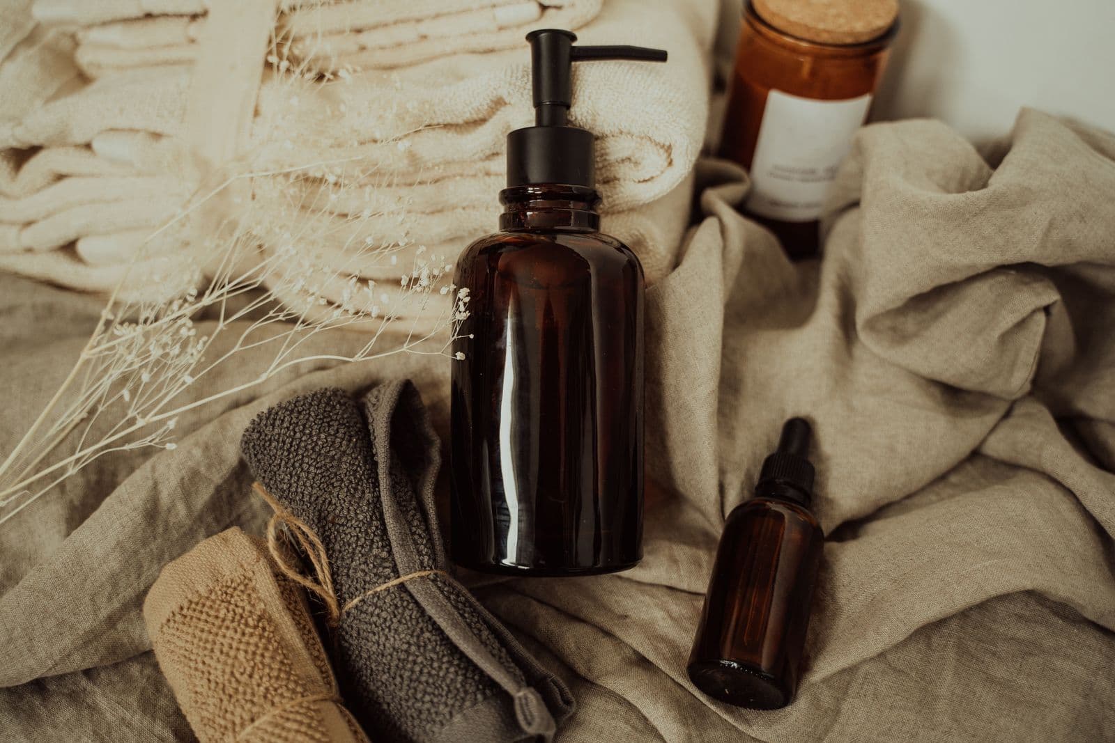 A few amber glass bottles resting on folded linen and towels